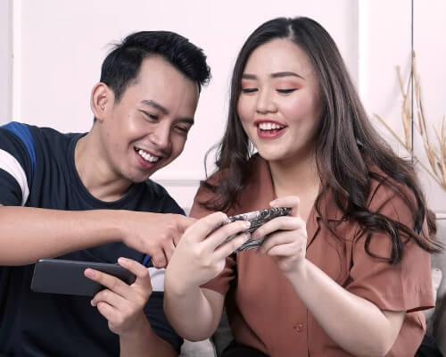 A couple browsing online next to each other.