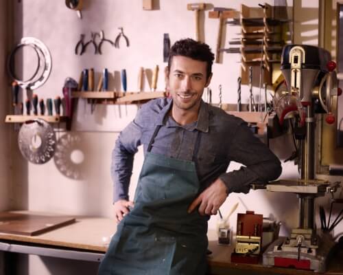 A business owner posing in his shop